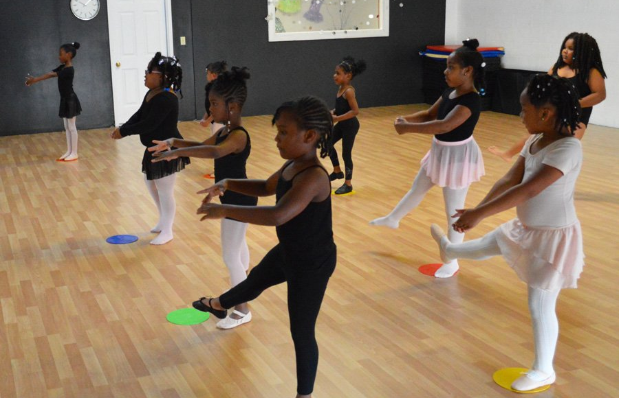 Young Dance ELITE ballet students working at the barre in class